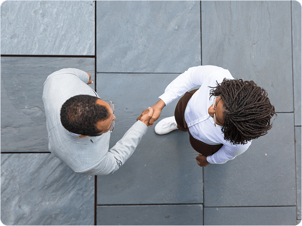 Two colleagues shaking hands, viewed from above