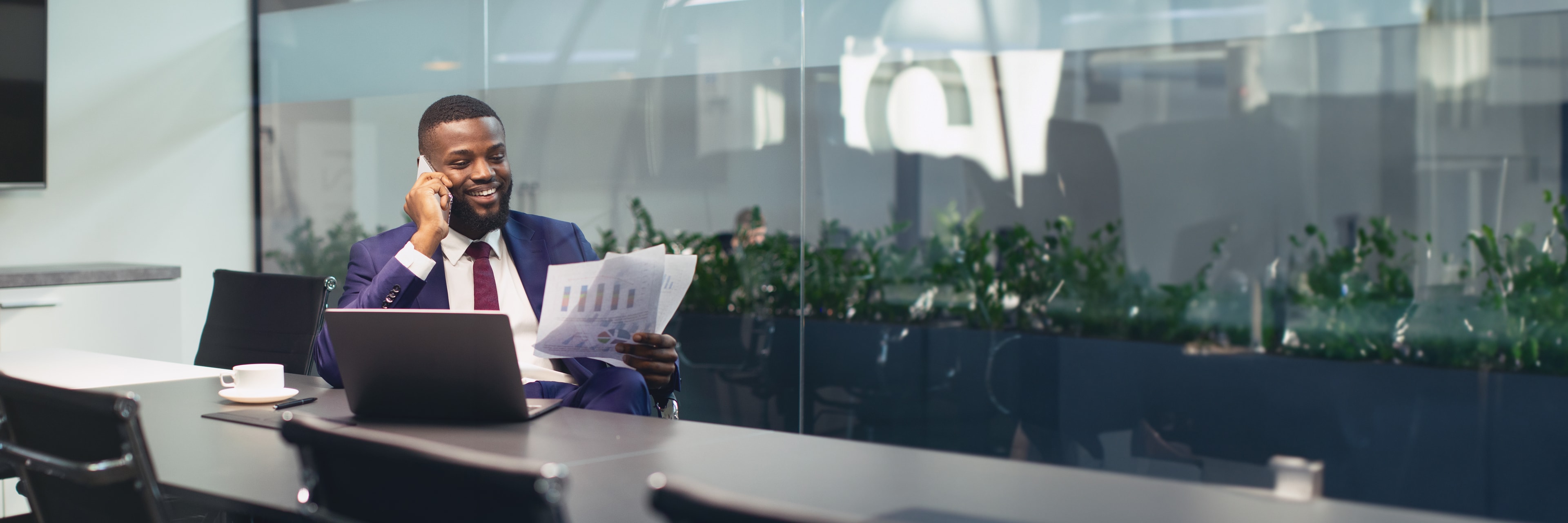 Business professional reviewing reports on a call in a modern office